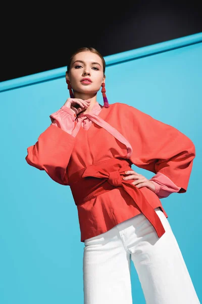 Modelo de moda hermosa en la ropa de coral de vida de moda posando en azul - foto de stock