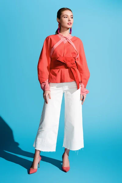 Fashionable woman posing in living coral clothing on blue — Stock Photo
