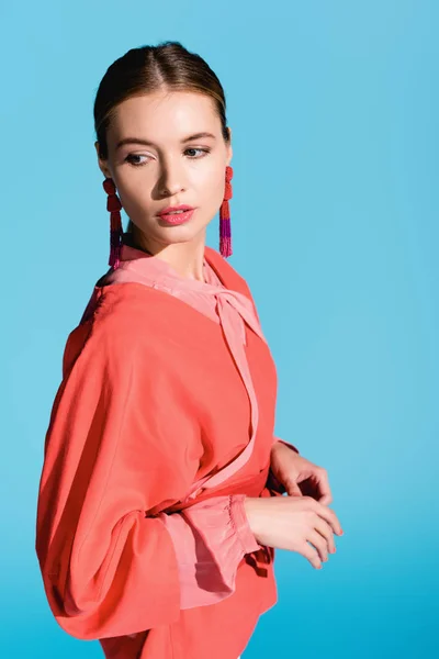 Fashionable girl posing in trendy living coral clothing isolated on blue — Stock Photo