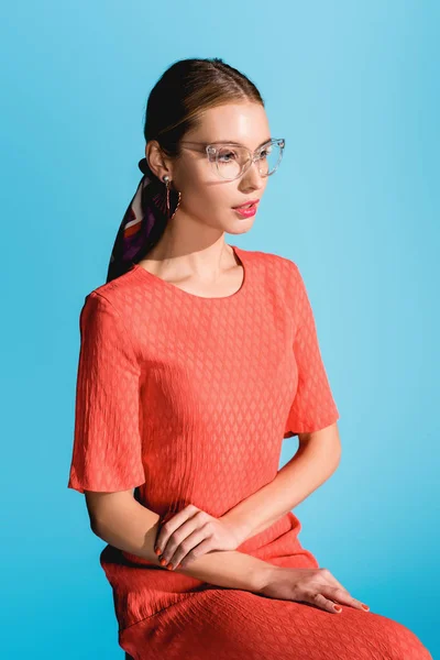 Fashionable girl posing in trendy living coral dress isolated on blue — Stock Photo