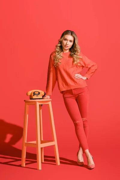 Fashionable girl posing with vintage rotary telephone on living coral. Pantone color of the year 2019 concept — Stock Photo