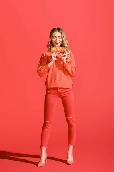 Mulher feliz segurando macaroons em corais vivos. Pantone cor do ano 2019 conceito — Fotografia de Stock