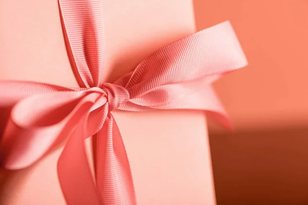 Close up of birthday present in living coral color. Pantone color of the year 2019 concept — Stock Photo