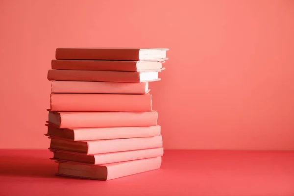 Stack of books on living coral background. Pantone color of the year 2019 concept — Stock Photo