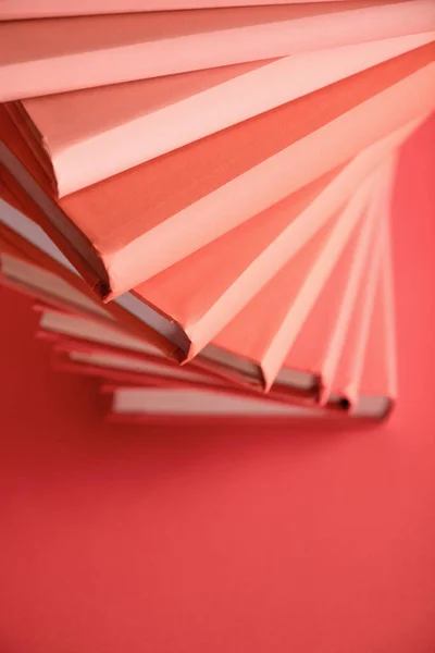 Stack of books on living coral background with copy space. Pantone color of the year 2019 concept — Stock Photo