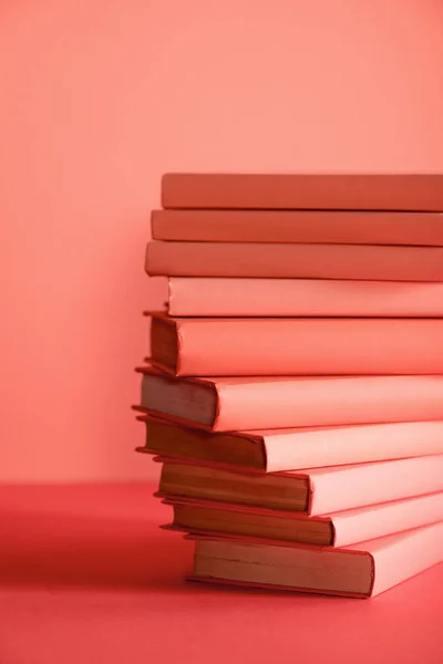 Pile of books on living coral background. Pantone color of the year 2019 concept — Stock Photo