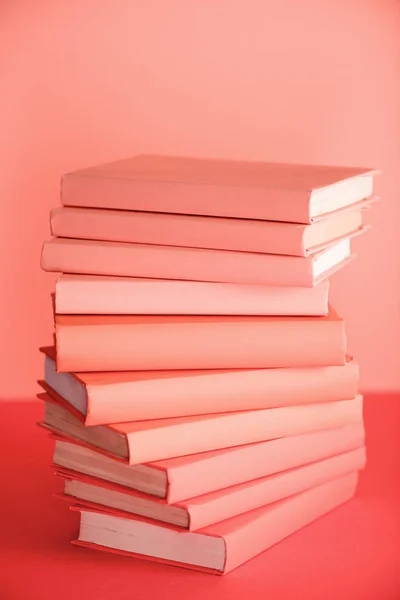 Стопка книг на живом коралловом фоне. Цвет пантона в концепции 2019 года — стоковое фото