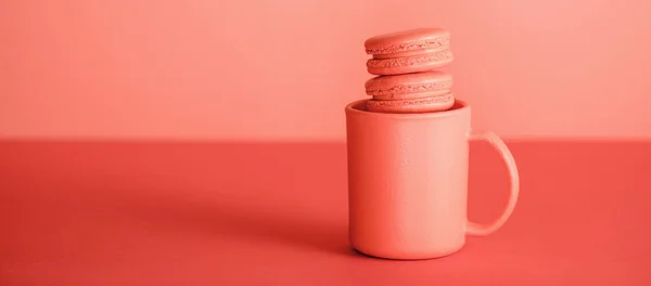 Солодкі макарони в чашці на модному Живому кораловому фоні. Концепція кольору пантона 2019 року — стокове фото
