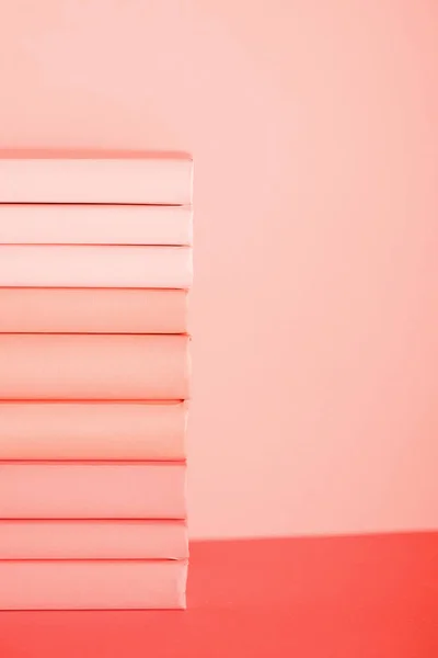 Pile de livres sur fond de corail vivant. Couleur Pantone de l'année 2019 concept — Photo de stock