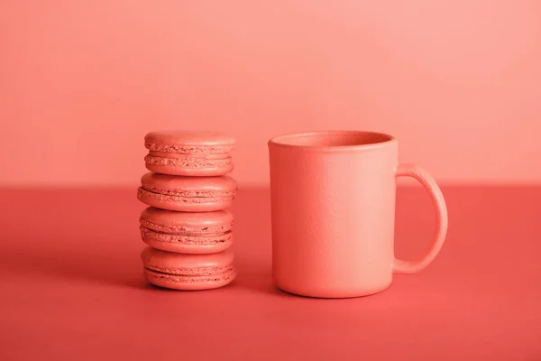 Tasse et macarons en couleur corail vivant. Couleur Pantone de l'année 2019 concept — Photo de stock