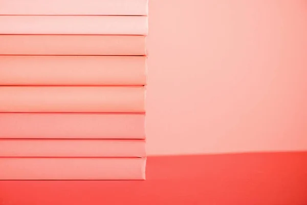 Stack of books on living coral background. Pantone color of the year 2019 concept — Stock Photo