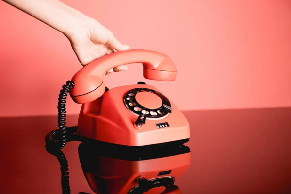 Partial view of woman with living coral vintage rotary telephone. Pantone color of the year 2019 concept — Stock Photo