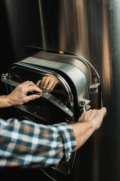 Vista ritagliata del birraio maschile che lavora con attrezzature da birreria — Stock Photo
