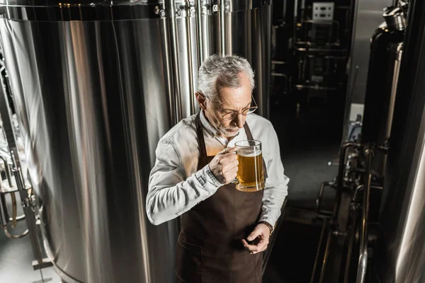 Propriétaire senior testant la bière dans une brasserie professionnelle — Photo de stock