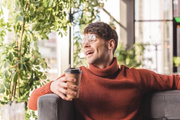 Uomo allegro in bicchieri che tengono tazza di carta in caffè — Foto stock