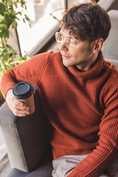 Vue aérienne de l'homme dans des lunettes tenant tasse en papier dans le café — Photo de stock