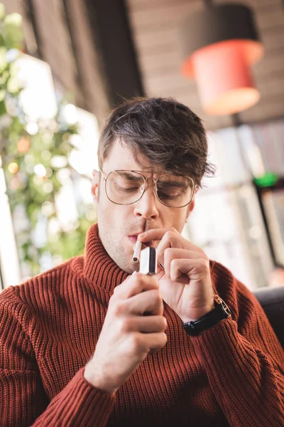 Hombre guapo en gafas fumar cigarrillo en la cafetería - foto de stock