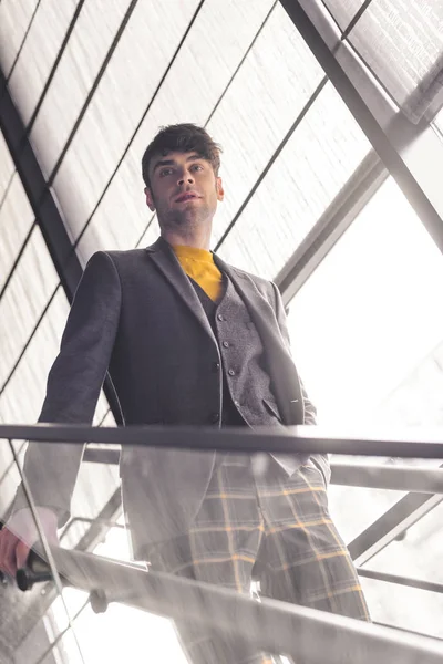 Homem elegante de pé com a mão no bolso nas escadas — Fotografia de Stock