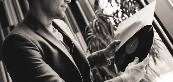 Vista recortada del hombre sosteniendo disco de vinilo en las manos, fotografía en blanco y negro - foto de stock