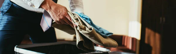 Обрізаний вид бізнесмена покласти одяг в дорожню сумку — Stock Photo