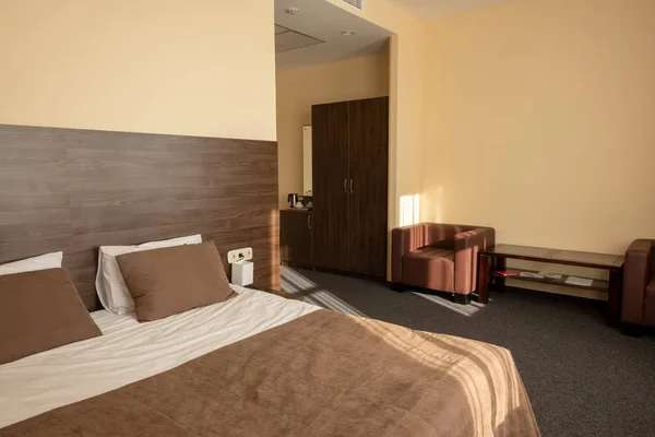 Hotel bedroom interior with bed in beige color — Stock Photo