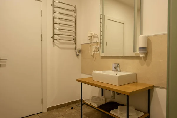 Salle de bain intérieure avec lavabo, serviettes, miroir et sèche-cheveux — Photo de stock