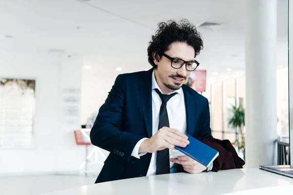 Handsome businessman making check-in with passport at the hotel — Stock Photo