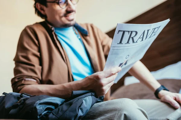 Focus selettivo di uomo lettura giornale di viaggio in camera d'albergo — Foto stock