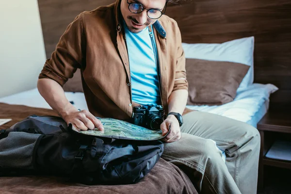 Schöner Reisender mit Brille, der im Hotelzimmer auf die Landkarte schaut — Stockfoto