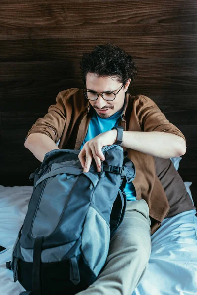Чоловічий мандрівника, бере щось від рюкзак у готельному номері — стокове фото