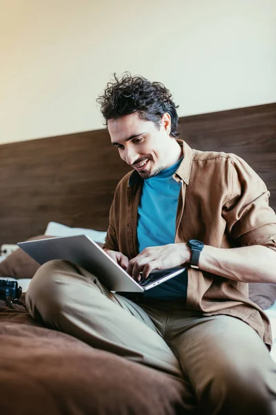 Glückliche männliche Touristin benutzt Laptop im Hotelzimmer — Stockfoto