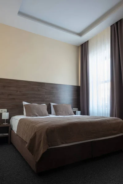 Hotel room interior with bed in brown color — Stock Photo