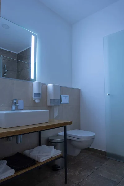 Interior do banheiro do hotel com pia, vaso sanitário, espelho e toalhas — Fotografia de Stock