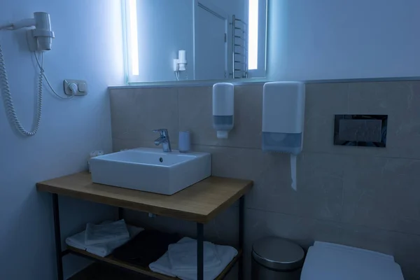 Bathroom with washstand, toilet, towels and hair dryer — Stock Photo