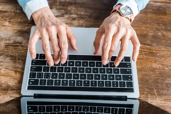 Vista dall'alto della donna anziana che digita sul computer portatile a casa — Foto stock