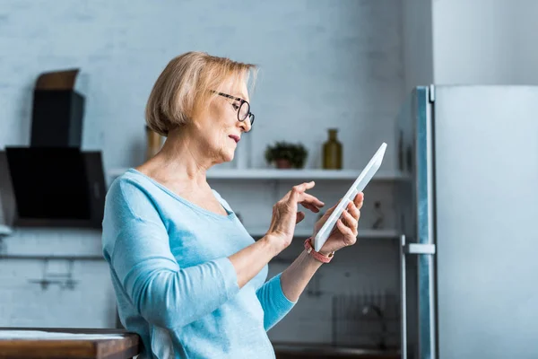 Seniorin nutzt digitales Tablet zu Hause — Stockfoto