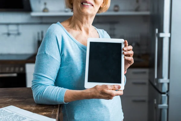 Vista ritagliata della donna anziana che presenta tablet digitale con schermo vuoto a casa — Foto stock