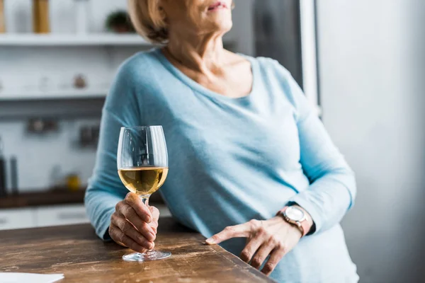 Обрізаний вид на старшу жінку, що тримає келих для вина вдома — стокове фото