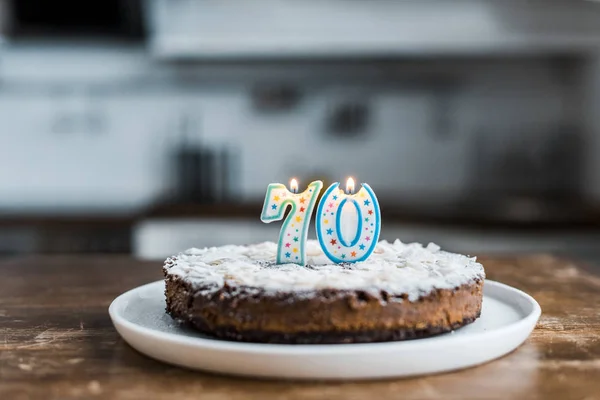 Foyer sélectif de délicieux gâteau d'anniversaire avec des bougies brûlantes et '70' signe sur le dessus — Photo de stock