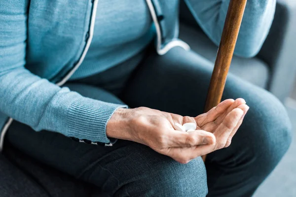 Ausgeschnittene Ansicht einer kranken Seniorin mit Gehstock in der Hand — Stockfoto