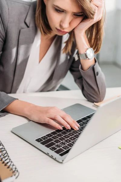 Erschöpfte attraktive Geschäftsfrau sitzt neben Laptop im Büro — Stockfoto