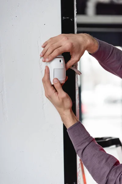 Vue recadrée du pompier tenant l'alarme incendie dans les mains — Photo de stock