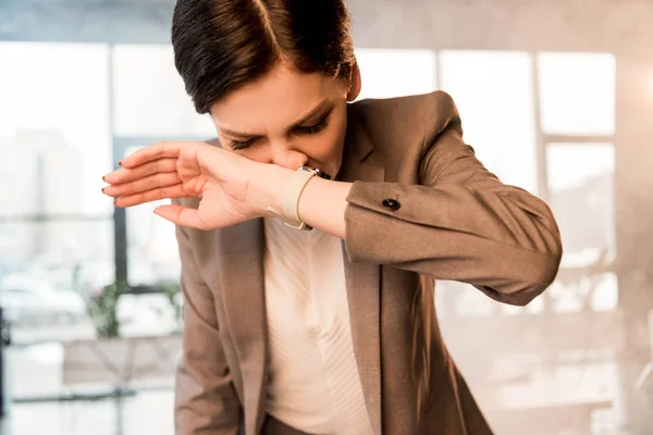 Beautiful scared woman covering nose in office with smoke — Stock Photo