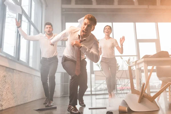 Uomini d'affari correre e urlare in ufficio con il fumo — Foto stock