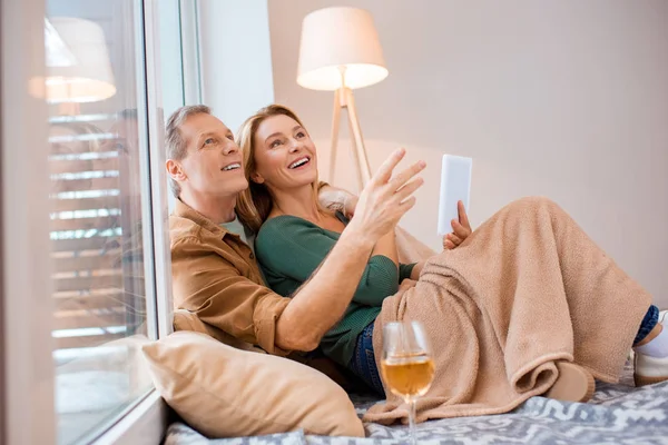 Happy couple looking up while using digital tablet — Stock Photo