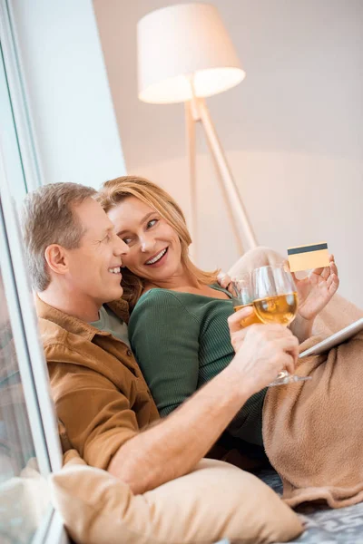 Pareja reflexiva mirándose entre sí mientras se utiliza el ordenador portátil juntos - foto de stock