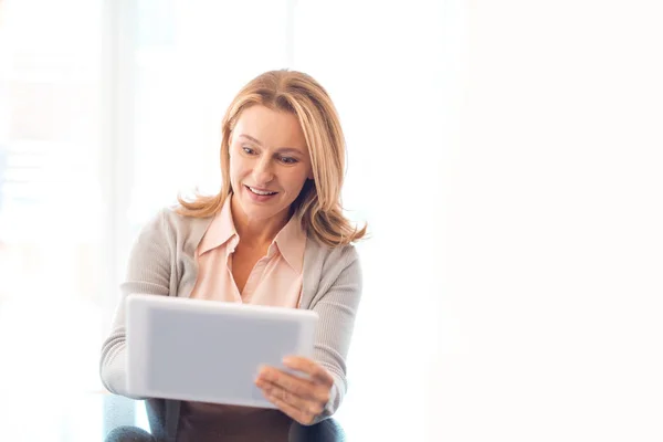 Mulher loira muito sorridente usando tablet digital — Fotografia de Stock