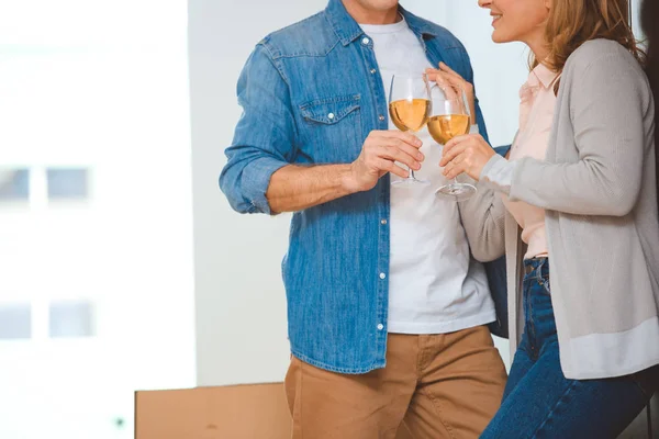 Cropped view of couple clinking glasses of white wine — Stock Photo