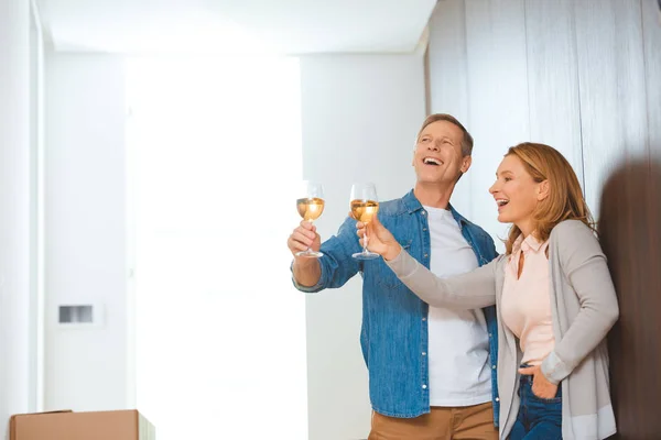 Aufgeregtes Paar mit Weißweingläsern im neuen Zuhause — Stockfoto