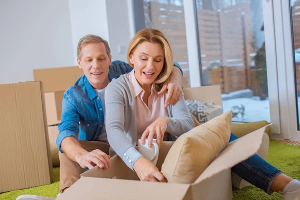Feliz pareja desembalaje cajas de cartón en el nuevo hogar - foto de stock